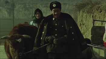 Movie still from “The Story of Qiu Ju” (1992), directed by Yimou Zhang – A man in a military uniform holding a sword; Medium shot, Low angle