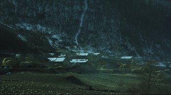 Movie still from “The Story of Qiu Ju” (1992), directed by Yimou Zhang – A group of houses on a hillside in the dark; Extreme Wide shot, High angle