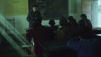 Movie still from “The Story of Qiu Ju” (1992), directed by Yimou Zhang – A group of people sitting in a classroom; Wide shot, High angle