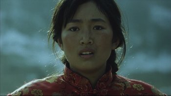 Movie still from “The Story of Qiu Ju” (1992), directed by Yimou Zhang – A young woman in a red and gold dress; Close Up shot, Low angle