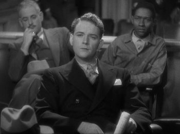 Movie still from “The Story of Temple Drake” (1933), directed by Stephen Roberts – A black and white photo of a man in a suit and tie; Medium shot, High angle