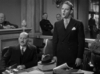 Movie still from “The Story of Temple Drake” (1933), directed by Stephen Roberts – A man in a suit and a tie standing in front of another man in a suit and a tie; Medium shot, Low angle