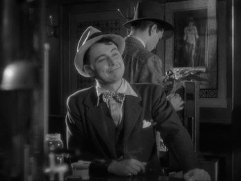 Movie still from “The Story of Temple Drake” (1933), directed by Stephen Roberts – A man wearing a hat and a suit and a tie; Medium shot, Low angle