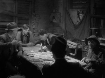 Movie still from “The Story of Temple Drake” (1933), directed by Stephen Roberts – A black and white photo of a group of people sitting at a table; Wide shot, High angle