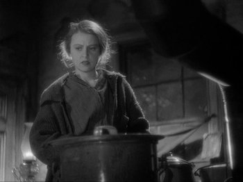 Movie still from “The Story of Temple Drake” (1933), directed by Stephen Roberts – A woman standing in front of a pot in a kitchen; Medium shot, Low angle