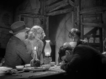 Movie still from “The Story of Temple Drake” (1933), directed by Stephen Roberts – A group of people sitting around a table with candles; Medium shot, High angle