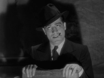 Movie still from “The Story of Temple Drake” (1933), directed by Stephen Roberts – A man wearing a suit and a hat; Close Up shot, Low angle