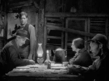Movie still from “The Story of Temple Drake” (1933), directed by Stephen Roberts – A black and white photo of a group of people sitting at a table; Wide shot, Over the shoulder angle