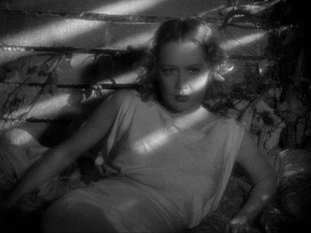 Movie still from “The Story of Temple Drake” (1933), directed by Stephen Roberts – A black - and - white photo of a woman sitting on the ground; Medium shot, High angle