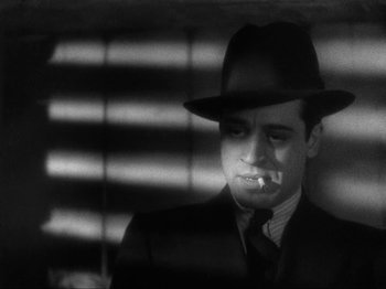 Movie still from “The Story of Temple Drake” (1933), directed by Stephen Roberts – A black and white photo of a man smoking a cigarette; Close Up shot, Low angle