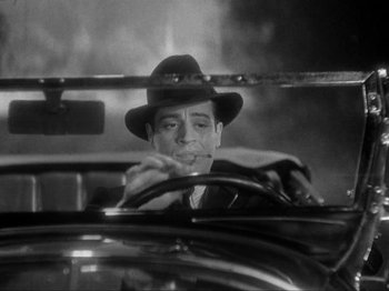 Movie still from “The Story of Temple Drake” (1933), directed by Stephen Roberts – A black and white photo of a man smoking a cigarette in the driver's seat of a car; Close Up shot, Low angle