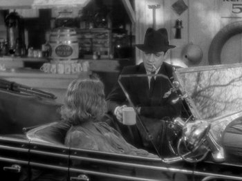 Movie still from “The Story of Temple Drake” (1933), directed by Stephen Roberts – A man pouring a cup of coffee to a woman in the back of a car; Medium shot, High angle