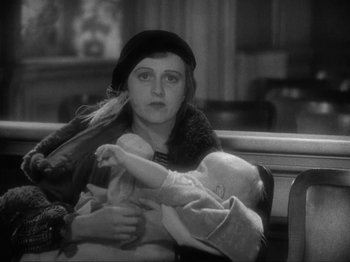 Movie still from “The Story of Temple Drake” (1933), directed by Stephen Roberts – An old photo of a woman holding a baby in her arms; Close Up shot, High angle