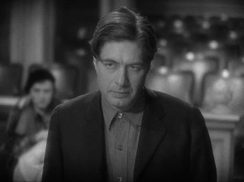 Movie still from “The Story of Temple Drake” (1933), directed by Stephen Roberts – A black and white photo of a man in a suit; Close Up shot, Over the shoulder angle