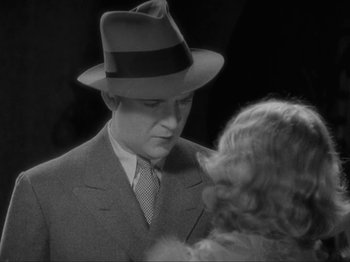 Movie still from “The Story of Temple Drake” (1933), directed by Stephen Roberts – A man in a suit and a hat talking to a woman in a dress; Close Up shot, High angle