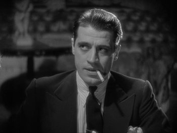 Movie still from “The Story of Temple Drake” (1933), directed by Stephen Roberts – A black and white photo of a man smoking a cigarette; Close Up shot, Low angle