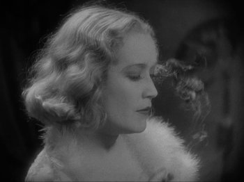 Movie still from “The Story of Temple Drake” (1933), directed by Stephen Roberts – A black - and - white photo of a woman smoking a cigarette; Close Up shot, Low angle