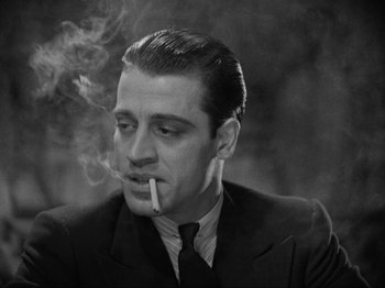 Movie still from “The Story of Temple Drake” (1933), directed by Stephen Roberts – A black and white photo of a man smoking a cigarette; Close Up shot, Low angle