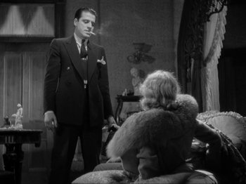 Movie still from “The Story of Temple Drake” (1933), directed by Stephen Roberts – A man in a suit and tie standing in front of a woman; Medium shot, Low angle