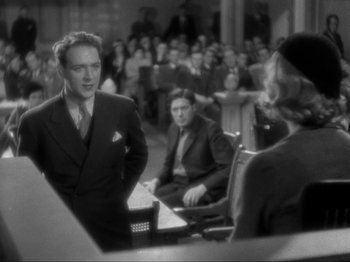 Movie still from “The Story of Temple Drake” (1933), directed by Stephen Roberts – A man in a suit and tie talking to a woman in a suit and tie; Medium shot, Over the shoulder angle