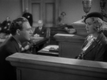 Movie still from “The Story of Temple Drake” (1933), directed by Stephen Roberts – A man and a woman are sitting in a court room; Medium shot, High angle