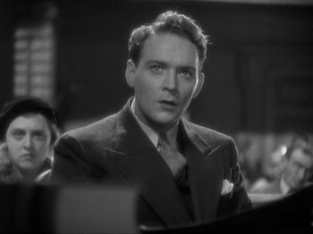 Movie still from “The Story of Temple Drake” (1933), directed by Stephen Roberts – A man wearing a suit and tie in front of a crowd; Close Up shot, Low angle