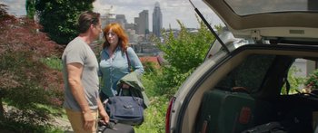 Movie still from “The Strangers: Prey at Night” (2018), directed by Johannes Roberts – A woman standing next to a man holding a suitcase; Medium shot, Over the shoulder angle