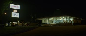 Movie still from “The Strangers: Prey at Night” (2018), directed by Johannes Roberts – A car parked in front of a building at night; Extreme Wide shot, Low angle