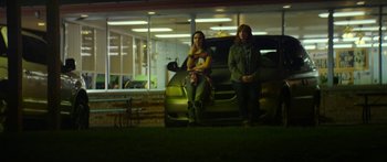 Movie still from “The Strangers: Prey at Night” (2018), directed by Johannes Roberts – Two women standing in front of a car at night; Wide shot, Low angle