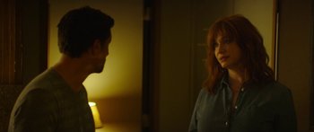 Movie still from “The Strangers: Prey at Night” (2018), directed by Johannes Roberts – A woman standing next to a man in front of a lamp; Medium shot, Over the shoulder angle