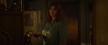 Movie still from “The Strangers: Prey at Night” (2018), directed by Johannes Roberts – A woman standing in a kitchen holding a bowl of food; Medium shot, Over the shoulder angle