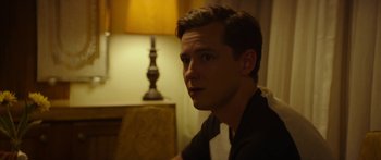 Movie still from “The Strangers: Prey at Night” (2018), directed by Johannes Roberts – A man sitting in front of a lamp in a room; Close Up shot, Over the shoulder angle