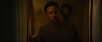 Movie still from “The Strangers: Prey at Night” (2018), directed by Johannes Roberts – A person in a room with a clock; Close Up shot, Over the shoulder angle
