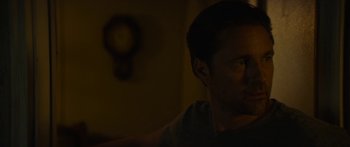 Movie still from “The Strangers: Prey at Night” (2018), directed by Johannes Roberts – A young man is sitting in a dark room; Close Up shot, Over the shoulder angle