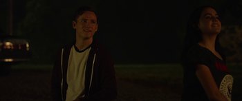 Movie still from “The Strangers: Prey at Night” (2018), directed by Johannes Roberts – A man in a white shirt is smiling at the camera; Close Up shot, Over the shoulder angle