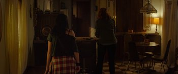 Movie still from “The Strangers: Prey at Night” (2018), directed by Johannes Roberts – Two women are standing in a kitchen preparing a meal; Wide shot, Over the shoulder angle