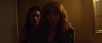 Movie still from “The Strangers: Prey at Night” (2018), directed by Johannes Roberts – Two women standing next to each other in a dark room; Close Up shot, Over the shoulder angle