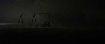 Movie still from “The Strangers: Prey at Night” (2018), directed by Johannes Roberts – An empty swing set in the middle of the night; Extreme Wide shot, High angle