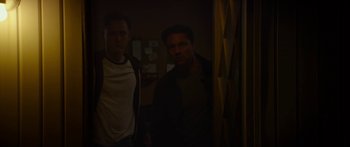 Movie still from “The Strangers: Prey at Night” (2018), directed by Johannes Roberts – Two men standing next to each other in the dark; Medium shot, Low angle