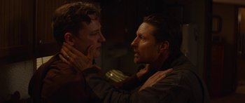 Movie still from “The Strangers: Prey at Night” (2018), directed by Johannes Roberts – A man and a boy are looking at each other in a dark room; Close Up shot, Over the shoulder angle