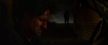 Movie still from “The Strangers: Prey at Night” (2018), directed by Johannes Roberts – A man standing next to a person in a dark field; Close Up shot, Low angle