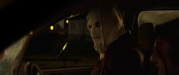 Movie still from “The Strangers: Prey at Night” (2018), directed by Johannes Roberts – A person in a car wearing a white mask; Close Up shot, Over the shoulder angle