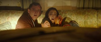 Movie still from “The Strangers: Prey at Night” (2018), directed by Johannes Roberts – A man and a woman sitting next to each other on a couch; Medium shot, High angle