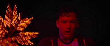 Movie still from “The Strangers: Prey at Night” (2018), directed by Johannes Roberts – A young man in the dark with red lighting; Close Up shot, Low angle