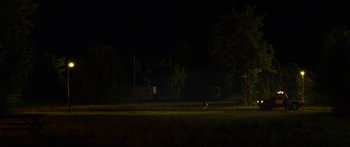 Movie still from “The Strangers: Prey at Night” (2018), directed by Johannes Roberts – A person riding a bike in a field at night; Extreme Wide shot, High angle