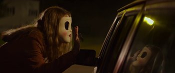 Movie still from “The Strangers: Prey at Night” (2018), directed by Johannes Roberts – A person with a mask is looking in a car window; Close Up shot, Low angle