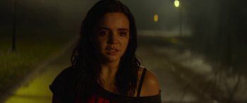 Movie still from “The Strangers: Prey at Night” (2018), directed by Johannes Roberts – A woman with long black hair standing in the dark; Close Up shot, Over the shoulder angle