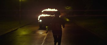 Movie still from “The Strangers: Prey at Night” (2018), directed by Johannes Roberts – A person walking down a street with an open umbrella; Wide shot, High angle