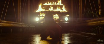 Movie still from “The Strangers: Prey at Night” (2018), directed by Johannes Roberts – A person kneeling down in front of a fire truck; Wide shot, Low angle