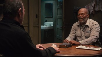 Movie still from “The Sunset Limited” (2011), directed by Tommy Lee Jones – Two men sitting at a table in front of each other; Medium shot, Over the shoulder angle